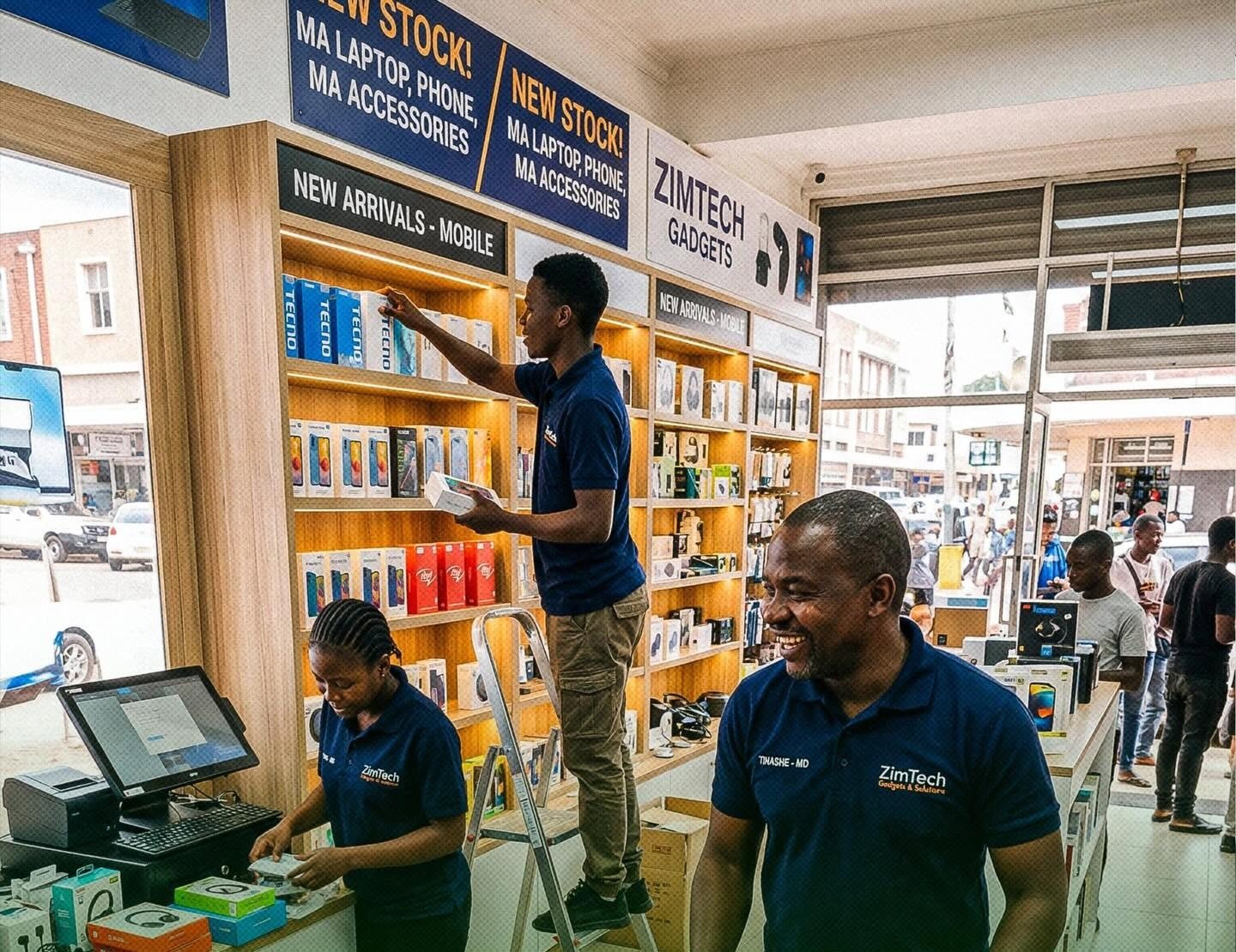 Shop owner and staff stocking shelves in a busy electronics store